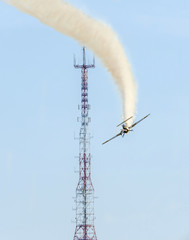 Obraz premium Aerobatic airplane pilot Jurgis Kairys training in the sky of the city. Airplane with trace smoke, airbandits, aeroshow.