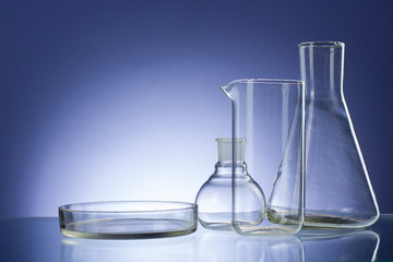 Assorted empty laboratory glassware, test-tubes. Blue tone medical background. Copy space