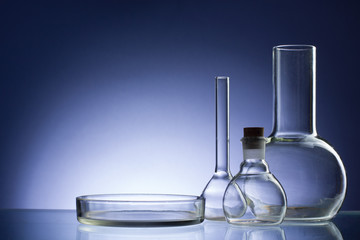 Assorted empty laboratory glassware, test-tubes. Blue tone medical background. Copy space