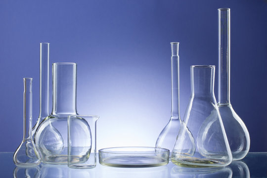 Assorted empty laboratory glassware, test-tubes. Blue tone medical background. Copy space