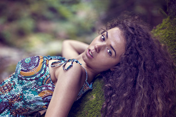 portrait of a beautiful woman with curly hair in nature