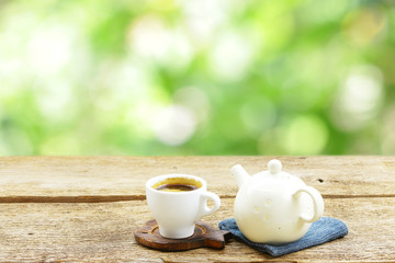 Tea cup with vintage old teapot on wooden table