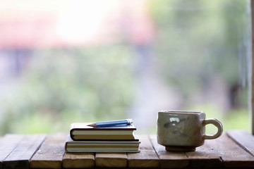 Notebook and  cup on wooden table