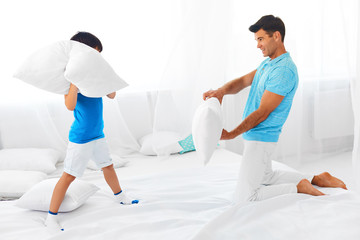 Obraz premium Dad and son having fun. Pillow fight.