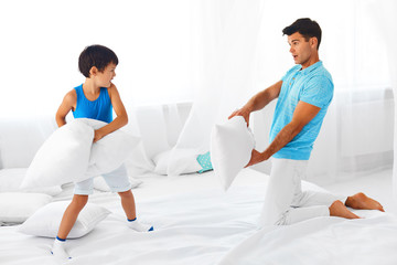Father and son having  a  pillow fight