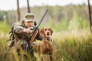 Fotobehang Jacht jager met een hond in het bos