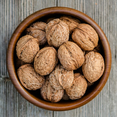 walnuts in a bowl - rustic wooden table