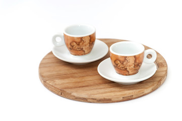 Pair of beautiful coffee mugs on the wooden board
