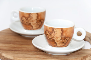 Pair of beautiful coffee mugs on the wooden board