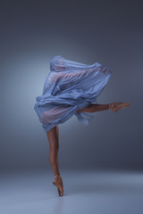 The beautiful ballerina dancing in blue long dress 