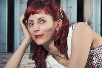 Fototapeta premium View of pinup young woman in vintage style clothing on a playground.
