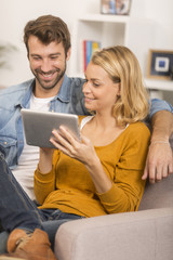 young couple using digital tablet at home