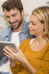 young couple using digital tablet at home