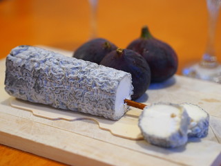 French cheese specialty - Sainte-Maure-de-Touraine fermier- aromatic fungal cheese made of goat's milk. Inside of the cheese is a piece of a straw, which creates a typical frame of this dairy product.