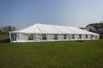Fototapeta na wymiar Tent white large mobile entertainment celebration facility structure on field