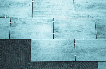 Laying ceramic tiles on a special cement grout. Selective focus.
