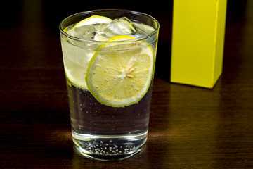 Gin and tonic. Spirit cocktail over dark wood table