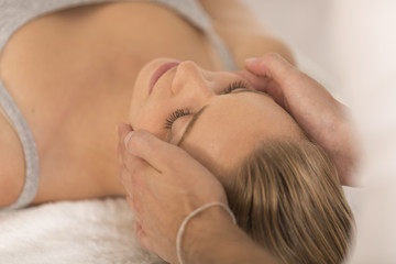Obraz na płótnie Canvas Masseur doing massage the head of an woman in spa salon