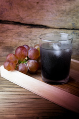 Fresh and juice grapes on wooden table