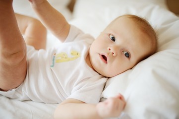 portrait of baby with blue eyes. A child resting on a bed