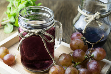 Fresh and juice grapes on wooden table