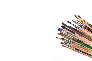 Big set of artist dirty paint brushes on white background with much space for text. Isolated image. 