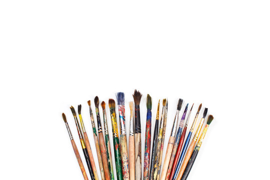 Big set of artist dirty paint brushes on white background with much space for text. Isolated image. 