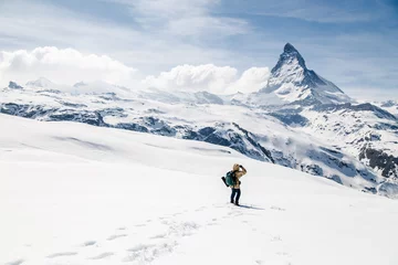 Photo sur Plexiglas Cervin A man standing on the snow looking at the background of Matterhorn.