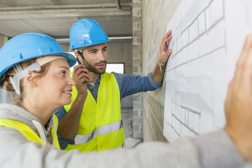 Engineers on building site checking plans