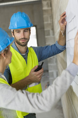 Engineers on building site checking plans