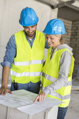 Engineers on building site checking plans