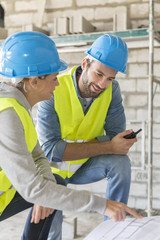 Engineers on building site checking plans