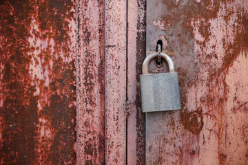 On the old wooden door, installed a rusty padlock