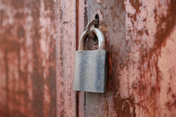 On the old wooden door, installed a rusty padlock