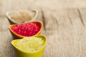 Colorful sea bath salts on wooden background. Spa, aromatherapy.