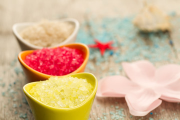 Colorful sea salts and seashells for the bathroom on wooden background. Spa, aromatherapy.