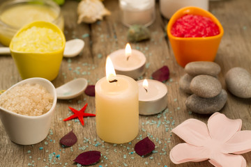 Fototapeta na wymiar Spa composition with sea salt, candles, soap, shells, creams for face on wooden background. Aromatherapy.