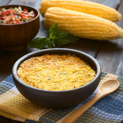 Traditional Chilean corn pie Pastel de Choclo, photographed with natural light. Below the corn-basil mix is ground meat, olive, boiled egg, raisin, chicken (Selective Focus, Focus one third into dish)