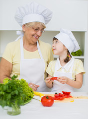 grandmother with granddaughter preparing a salad