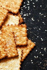 Sweet crackers, sesame, sugar grains on a dark background, top v