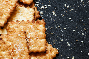 Sweet crackers, sesame, sugar grains on a dark background, top v