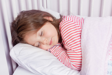 cute little girl sleeping in her bed