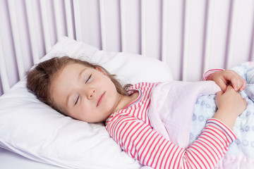 cute little girl sleeping in her bed