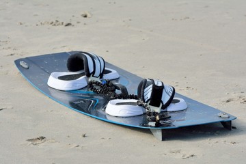 Planche de kitesurf posée sur le sable d'une plage bretonne