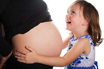 Happy little girl and belly of her pregnant mother