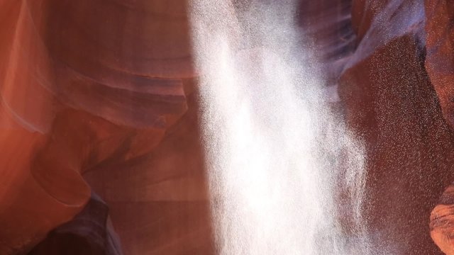 Sand Falling in Ray of Light in Antelope Canyon