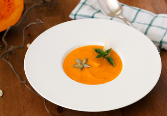 squash soup in a plate with basil leaf
