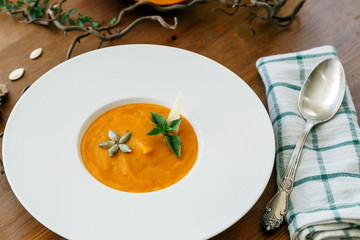Pumpkin soup in white modern plate, dietary vegetable