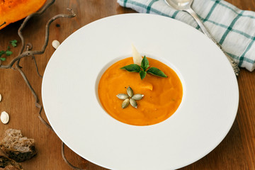 Pumpkin soup in white modern plate, dietary vegetable