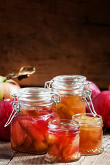 Autumn apple jam ripe red apples in jars on an old wooden table,